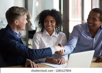 During business meeting with new participants people introducing themselves before starting negotiations. Multiracial businessmen client and company ceo greeting each other shake hands showing respect