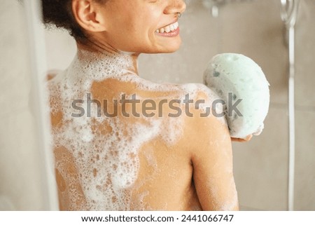 During the event of bathing, she washes her back with a sponge