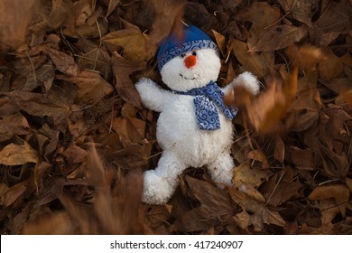 During The Golden Hour Of The Day, A Snowman Has Fun Playing In The Autumn Leaves, Making Snow Angels, Throwing Leaves In The Air And Escaping The Chill Of Winter. Horizontal, Flat Layout, Copy Space.