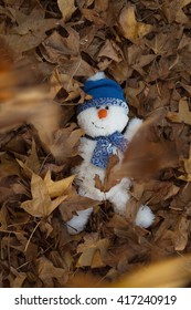 During The Golden Hour Of The Day, A Snowman Has Fun Playing In The Autumn Leaves, Making Snow Angels, Throwing Leaves In The Air And Escaping The Chill Of Winter. Vertical, Flat Layout, Copy Space.