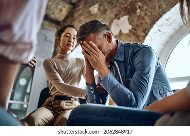 During Group Therapy Session Participants Supporting Crying Desperate Guy, Provide Psychological Assistance Talking Encouraging Words Share Mental Pain Try To Help, Struggle With Addictions Treatment.