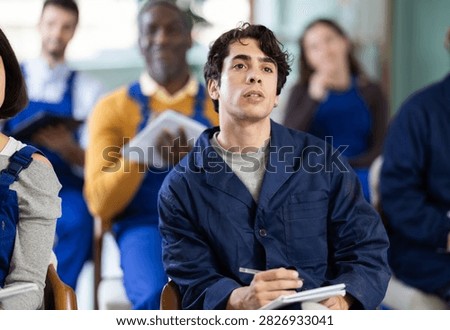 During lesson, guy worker employee listens to lecture and writes down main theses. Introductory lecture for new employees and theoretical introduction to profession