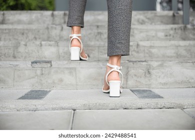 During morning rush businesswoman legs in motion are focused on ascending office stairs. Her determined foot represents journey of achievement, progress and success in dynamic business environment. - Powered by Shutterstock