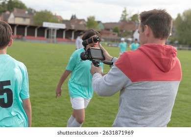 During a soccer practice session taking place on a lush green grassy field, a dedicated coach records a young players progress
