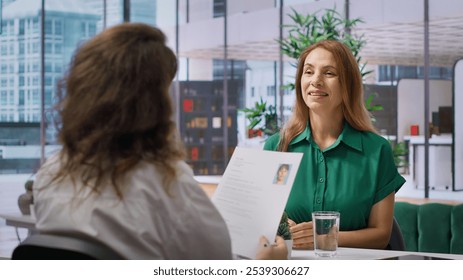 During a structured job interview, applicant presents her cv to a business recruiter, elaborating on their career history and aspirations. Career development within the enterprise. Camera A.