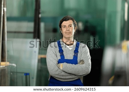 During work process, man employee produces blanks for repairs and interior decoration. He carries out installation work, products for renovation of residential premises made of glass and plastic.