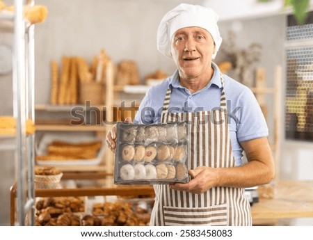 Similar – Image, Stock Photo Baker picking bread from the conveyor belt