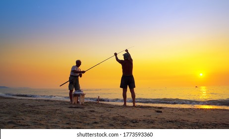 Durres, Albania - 10 Aug, 2019: Silhouette of active fisherman fishing with rod at summer sea sunset