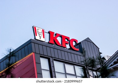 DUSHANBE, TAJIKISTAN - JULY 28, 2022: Red KFC fast food restaurant logo with Colonel Sanders against the blue sky