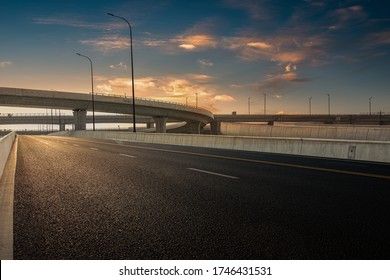 Dusk colored clouds in the background, highway overpass curved approach bridge 