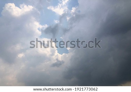 Dusk grey cloudy against soft blue sky. Gloomy sky. Natural climate change with rainy clouds background. Winter season sky in Thailand.