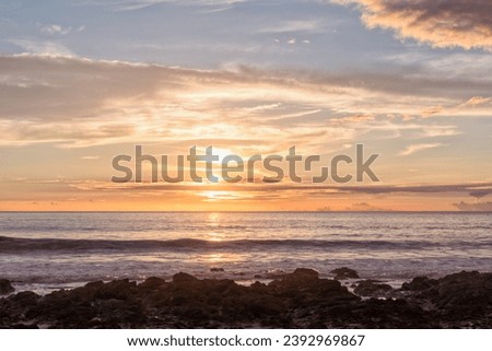 Dusk landscae on the ocean with a Rocky Beach in the Foreground, Flamingo Beach, Costa Rica