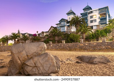 Dusk settles over the quaint seaside town of Papudo casting a serene purple glow over the rocky shore highlighting it's charming coastal architecture, Papudo, Valparaiso region, Chile - Powered by Shutterstock