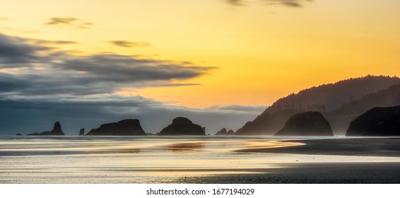 Dusk Or Sunset At Cannon Beach With Shoreline And Silhouetted Sea Stacks, Oregon Coast Scenery Or Landscape, Usa.