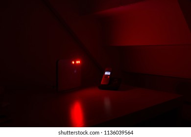 Dusseldorf, North Rhine-Westphalia, Germany, September 2017.  Telephone And Modem On The Desk In Red Light