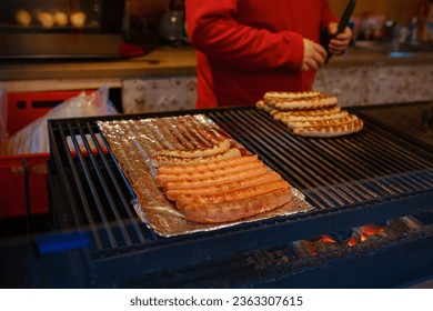 Dusselldorf, Germany - December 13, 2022: Bratwurst famous fried sausages, Grilling sausages on barbecue grill at food stall of Christmas market, winter wonderland. - Shutterstock ID 2363307615