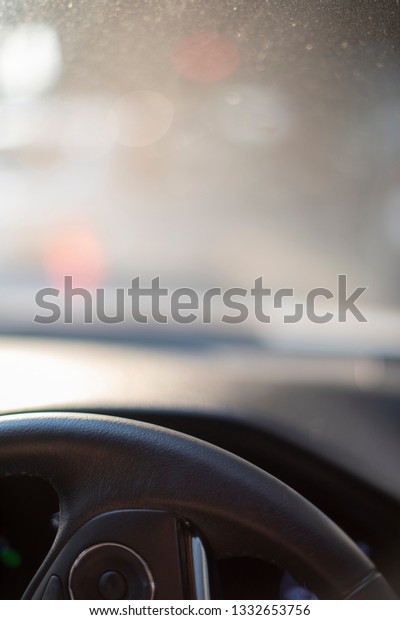 A dust air pollution seen\
from a car windshield interior during a morning time in a traffic\
jam.