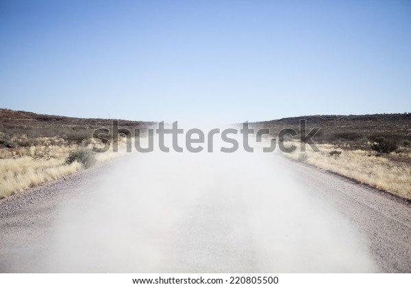 Dust of car on dirt\
road