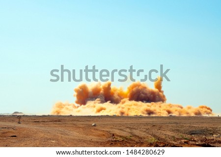 Dust clouds after the detonator blasting in the desert 