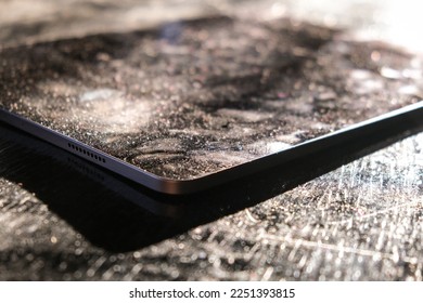 Dust particles and fingerprints are seen on a tablet in a beautiful light - Shutterstock ID 2251393815
