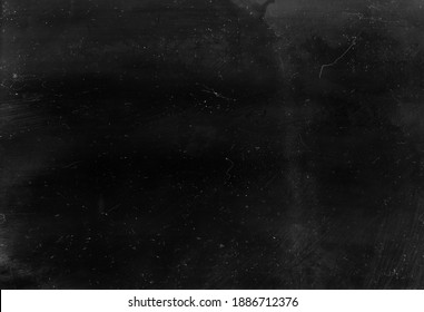 Dust scratched overlay. Weathered chalkboard. Black distressed aged stained surface with gray smeared dirt grainy particles noise effect.
