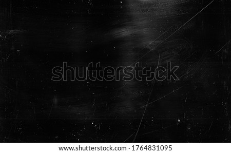 Dust scratches background. Grain texture. Black distressed surface with white smeared stains.