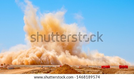 Dust storm after the detonator blast on the construction site 