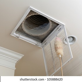 Dusting The Vent For Air Conditioning Filter In Ceiling Of Modern Home