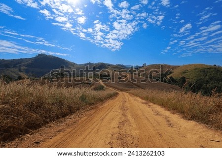 Dusty mountain road, beautiful sky,Dirt road in the mountains northern Thailand.