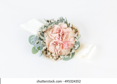 Dusty pink carnation wrist corsage isolated on white background