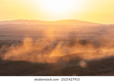 Dusty road in Tuscany illuminated by warm sunset light, hills and trees in the background. Warm golden sunlight filters through the dust on a road, distant hills barely visible.
