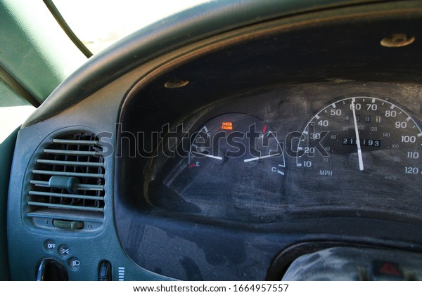 Dusty truck dashboard with speedometer, gas gauge,\
and heat gauge