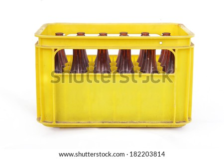 Dusty vintage yellow beer crate with empty brown beer bottles on white background