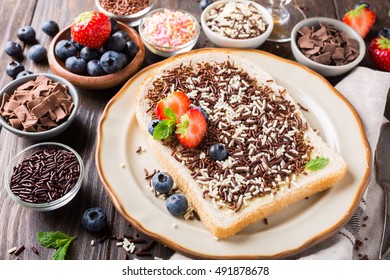 Dutch breakfast, slice of bread with hagelslag chocolate sprinkles and berries.