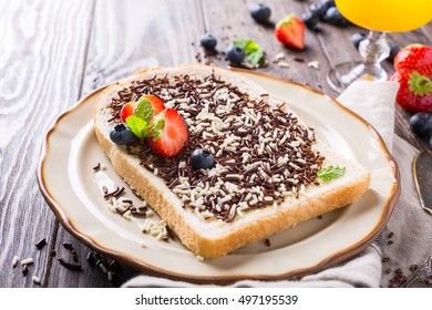 Dutch breakfast, slice of bread with hagelslag chocolate sprinkles and berries.