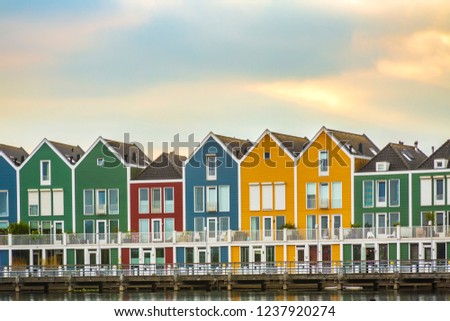 Dutch, modern, colorful vinex architecture style houses at waterside during dramatic and clouded sunset. Houten, Utrecht.