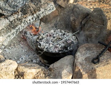 Dutch Oven Cooking With Charcoal Embers In Smoky Fire Pit