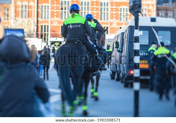 Dutch police squad formation and horseback riding\
mounted police back view with \