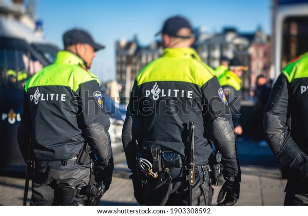 Dutch police squad formation and horseback riding\
mounted police back view with \