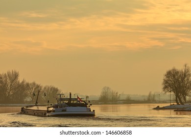 Dutch riverboat transporting goods during winter on the river IJssel