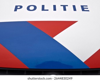 Letrero holandés Politie (Policía) y franjas rojas y azules en vehículo policial en los Países Bajos