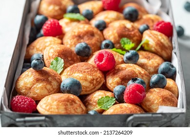 Dutch and sweet mini pancakes as a Danish breakfast. Poffertjes with fruits as sweet breakfast.