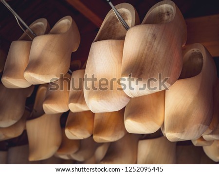 Dutch traditional wooden shoes closeup. Typical carved holland clogs - ancient farmer footwear and popular souvenir in tourist shops, symbol of the Netherlands.