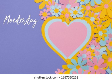 Dutch word Moederdag with paper hearts and paper flowers. On a lilac background. Room for text. 