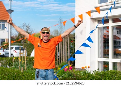 Dutchman Celebrating Kings Day On The Road During A Street Party Dressed In Orange In Holland The Netherlands. Koningsdag Is A Traditional Festival To Celebrate The Dutch Royal Family. Dutch Bunting.