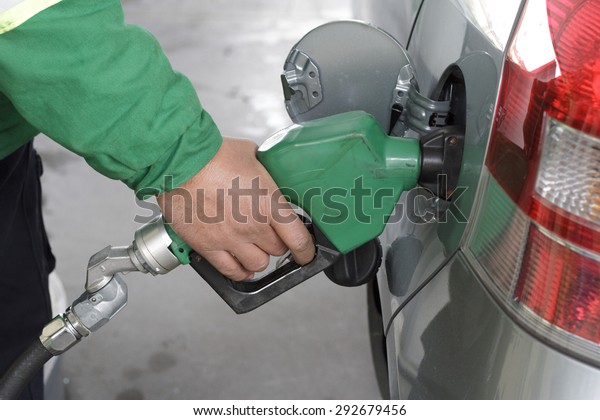 a duty refueling\
the car at a gas station