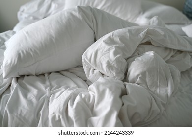 Duvet Crumpled After People Got Out Of Bed. Soft Bedding Set Are Suitable For Sleeping And Relaxing. Pillow Wearing White Pillowcases And White Satin Sheets,