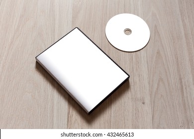 Dvd or cd disc cover case mockup. Template with plastic box and disc with white isolated free space for design. Mock up with black package for compact or dvd disc. On wooden table background