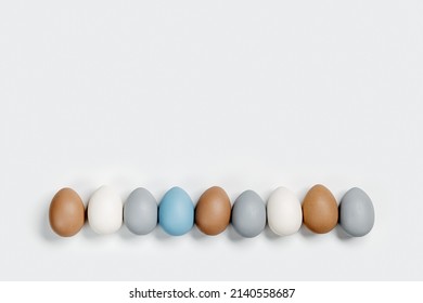 Dyed Easter Eggs Pastel Colors Blue, Gray, Beige In Row On White Background. Happy Easter Holiday, Celebration Food Concept, Chicken Egg Neutral Trendy Color. Top View Table, Copy Space.