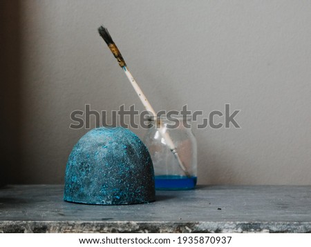 
dyeing process in cement object with sulfate technique. Grey background. Verdigris painting